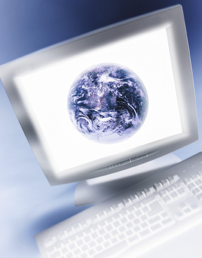 a desktop computer monitor displaying an image of the earth on the screen.